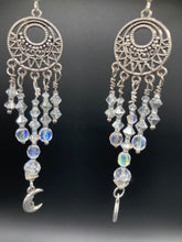 Load image into Gallery viewer, Crafted with five strands of stunning clear iridescent glass beads and dangling crescent moons, these large chandelier style earrings will add a celestial touch to any outfit.  Measurements: 4” in length

