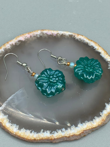 Upgrade your style with these sophisticated blue-green floral pressed glass earrings. Their iridescent glimmer finish adds a glamorous touch for any occasion. Crafted from lightweight glass, each design is both eye-catching and comfortable to wear. Measurements: 1 1/4