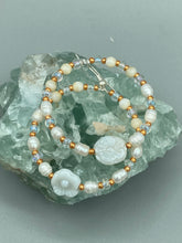 Load image into Gallery viewer, These white floral glass beaded hoop earrings bring a bohemian, shabby-chic, and nature-inspired vibe to any look. Crafted with small iridescent, gold, and white glass beads, they are the perfect accessory for any fashionista who loves beach vibes, summer elements, and chic boho styles. Measurements: 2 1/4" length
