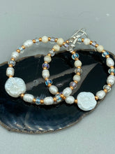 Load image into Gallery viewer, These white floral glass beaded hoop earrings bring a bohemian, shabby-chic, and nature-inspired vibe to any look. Crafted with small iridescent, gold, and white glass beads, they are the perfect accessory for any fashionista who loves beach vibes, summer elements, and chic boho styles. Measurements: 2 1/4" length
