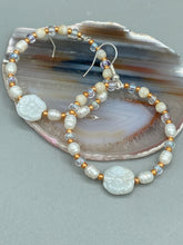 Load image into Gallery viewer, These white floral glass beaded hoop earrings bring a bohemian, shabby-chic, and nature-inspired vibe to any look. Crafted with small iridescent, gold, and white glass beads, they are the perfect accessory for any fashionista who loves beach vibes, summer elements, and chic boho styles. Measurements: 2 1/4" length
