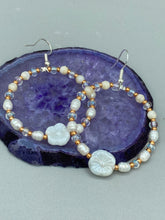 Load image into Gallery viewer, These white floral glass beaded hoop earrings bring a bohemian, shabby-chic, and nature-inspired vibe to any look. Crafted with small iridescent, gold, and white glass beads, they are the perfect accessory for any fashionista who loves beach vibes, summer elements, and chic boho styles. Measurements: 2 1/4" length
