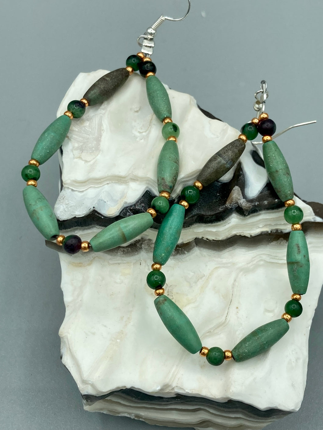 These stylish fish hook style earrings feature intricate beadwork crafted with forest green magnesite and ruby zoisite stones. Measurements: 2 3/4