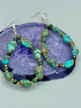 Load image into Gallery viewer, These earrings feature blue-green magnesite and ruby zoisite stones set in gold glass beaded hoops. Measurements: 2 1/2&quot; length 
