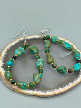 Load image into Gallery viewer, These earrings feature blue-green magnesite and ruby zoisite stones set in gold glass beaded hoops. Measurements: 2 1/2&quot; length 
