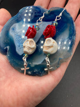 Load image into Gallery viewer, Frida Kahlo Inspired Earrings, Chicana Chingona Chola Style Jewelry. Howlite Skull Bead With Red Quartize Rose Beads. Beautifully and elegant set of earrings captures Frida Kahlo&#39;s signature floral crown on her head, dangling silver plated cross gives these earrings some movement. These are a beautiful piece of jewelry to wear for inspiration or a great Dia De Los Muertos jewelry piece. You can dress these up or down, it will definitely give your outfit a unique look. 2 ” in length
