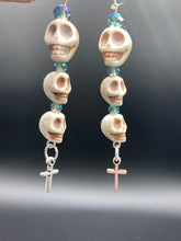 Load image into Gallery viewer, For The Dark Souls Three Howlite Skull Beads Light Blue Iridescent Glass Bead Earrings Dangling Silver Plated Cross Give These Earrings Movement. Chingona, Cabrona, Latina Chicana, Goth, Vampire Goth, Dark Witchy Style. You can dress these up or down, it will definitely give your outfit a unique look.  Measurements: 3 ” in length
