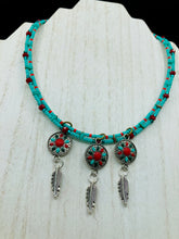 Load image into Gallery viewer, This two-stranded necklace features a vibrant Southwest-inspired design. Hand-beaded turquoise, bright red, and dark green colors, along with silver-plated feather charms, add dynamic movement to the piece. An ideal set for chingona guerrera carbonas, la India princesses, warrior cosplay, and other native-inspired looks.  Measurements:  Necklace is 15” adjustable up to 18" in length
