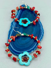 Load image into Gallery viewer, These earrings feature a turquoise magnesite floral bead with a dark red glass bead in the center and artfully beaded with bamboo red coral and turquoise stones. Measurements: 1 3/4" length
