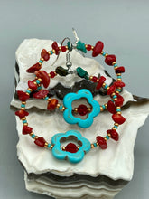 Load image into Gallery viewer, These earrings feature a turquoise magnesite floral bead with a dark red glass bead in the center and artfully beaded with bamboo red coral and turquoise stones. Measurements: 1 3/4" length

