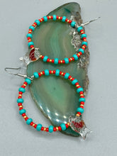 Load image into Gallery viewer, This eye-catching set of earrings features intricately detailed koi fish glass beads, accompanied by smaller teal, red, and gold-hued glass beads. With their bold and vibrant colors, they make a striking statement.  Measurements: 2 1/4” in length   
