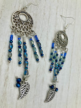 Load image into Gallery viewer, These intricate moroccan blue Inspired large chandelier earrings boast five strands of blue and iridescent glass beads of various hues, including silver and gold. Additionally, two small dark blue glass beads with a silver leaf add a touch of dimension and motion. The perfect addition to any Fairy Princess or whimsical aesthetic.  Measurements: 4” in length
