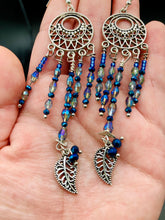 Load image into Gallery viewer, These intricate moroccan blue Inspired large chandelier earrings boast five strands of blue and iridescent glass beads of various hues, including silver and gold. Additionally, two small dark blue glass beads with a silver leaf add a touch of dimension and motion. The perfect addition to any Fairy Princess or whimsical aesthetic.  Measurements: 4” in length
