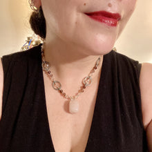 Load image into Gallery viewer, This exquisite necklace features a soft pink Rose Quartz pendant with multi-colored glass beads that transition from iridescent pink, to light purple and darker shades of purple. The sequence of beads complements the Rose Quartz pendant&#39;s delicate hue, and is accompanied with a set of subtly-styled matching earrings for a complete look.  Measurements:   Necklace is 16 1/2”
