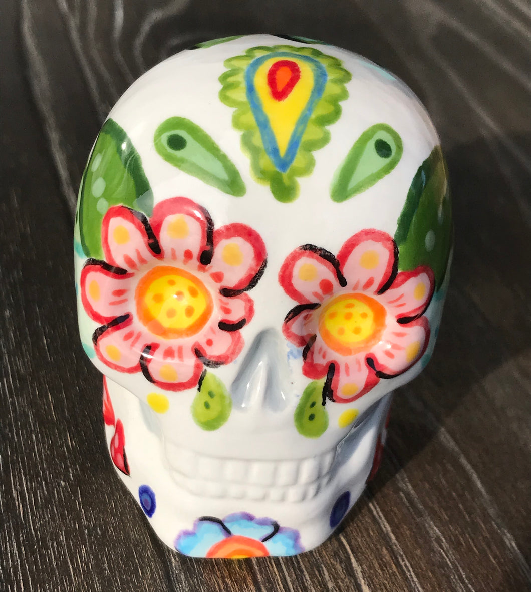 Bring Southwest beauty to any space with this unique ceramic sugar skull art. Hand-painted with bright colors, this piece captures the spirit of Sedona in a Dia de Los Muertos ofrenda. Let this delightful piece evoke the magical beauty of the amazing landscape you'll never forget. H 2 3/4” x W 2” x D 2”