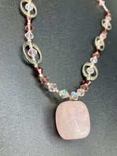 Load image into Gallery viewer, This exquisite necklace features a soft pink Rose Quartz pendant with multi-colored glass beads that transition from iridescent pink, to light purple and darker shades of purple. The sequence of beads complements the Rose Quartz pendant&#39;s delicate hue, and is accompanied with a set of subtly-styled matching earrings for a complete look.  Measurements:   Necklace is 16 1/2”
