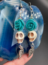 Load image into Gallery viewer, Frida Kahlo Inspired Earrings, Howlite Skull And Turquoise Quartize Floral Beads. This beautifully and elegant set of earrings captures Frida Kahlo&#39;s signature floral crown on her head. Dangling silver plated intricate leaf at the bottom to give these earrings some movement. These are a beautiful piece of jewelry to wear for inspiration or a great Dia De Los Muertos jewelry piece. Chingona, Cabrona, Latina Chicana, Goth, Vampire Goth, Dark Witchy Style. 2 ” in length

