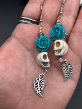 Load image into Gallery viewer, Frida Kahlo Inspired Earrings, Howlite Skull And Turquoise Quartize Floral Beads. This beautifully and elegant set of earrings captures Frida Kahlo&#39;s signature floral crown on her head. Dangling silver plated intricate leaf at the bottom to give these earrings some movement. These are a beautiful piece of jewelry to wear for inspiration or a great Dia De Los Muertos jewelry piece. Chingona, Cabrona, Latina Chicana, Goth, Vampire Goth, Dark Witchy Style. 2 ” in length

