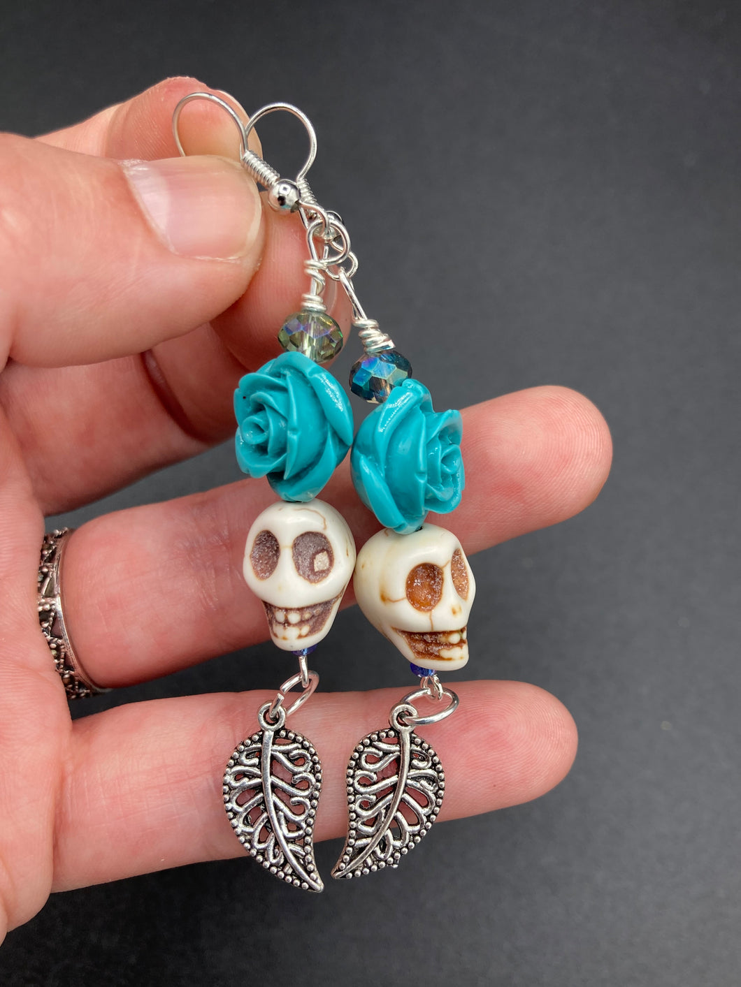 Frida Kahlo Inspired Earrings, Howlite Skull And Turquoise Quartize Floral Beads. This beautifully and elegant set of earrings captures Frida Kahlo's signature floral crown on her head. Dangling silver plated intricate leaf at the bottom to give these earrings some movement. These are a beautiful piece of jewelry to wear for inspiration or a great Dia De Los Muertos jewelry piece. Chingona, Cabrona, Latina Chicana, Goth, Vampire Goth, Dark Witchy Style. 2 ” in length