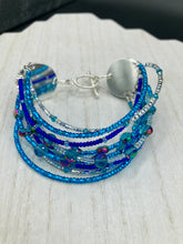 Load image into Gallery viewer, This Ocean Blue Waves Nine Stands Glass Beaded Chunky Wide Bracelet is the ideal accessory for any summer seaside look. Measurements: 8&quot; in length
