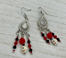 Load image into Gallery viewer, Frida Kahlo Inspired Earrings, Tiny Howlite Skull Beads With Red Quartize Rose Beads. Elegant set of earrings captures Frida Kahlo&#39;s signature floral crown on her head. Red and black shimmery glass beads to give a little pop of color and incorporated some movement. These are a beautiful piece of jewelry to wear for inspiration or a great Dia De Los Muertos jewelry piece. You can dress these up or down, it will definitely give your outfit a unique look. 2 ” in length
