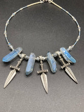 Load image into Gallery viewer, This elegant and dark necklace features shimmering light silver and gray glass beads of varying sizes and shapes for texture and dimension. The necklace is finished with blue luster crystal stone nuggets and nickel-free dagger pendants, creating a beautiful draping effect. Measurements:   Necklace is 17”adjustable up to 19&quot; 
