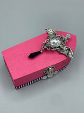 Load image into Gallery viewer, This unique handmade Pink Spooky Glam Wood Coffin Ring Box offers a statement piece for your witchy home decor. Its macabre collections boast a black and pink wood coffin with large shimmery bat embellishments and decorative black crystals around the exterior. Open up the box to find a bright turquoise mandala fabric and a tiny black crystal bat decoration for a truly eerie feel.
