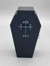 Load image into Gallery viewer, This unique vintage-inspired ring box is perfect for storing your jewelry and other special items. The wood coffin design is accented with a detailed black silver cross. The interior is lined with a skull fabric and a large dark red rose, adding a spooky yet elegant flair.
